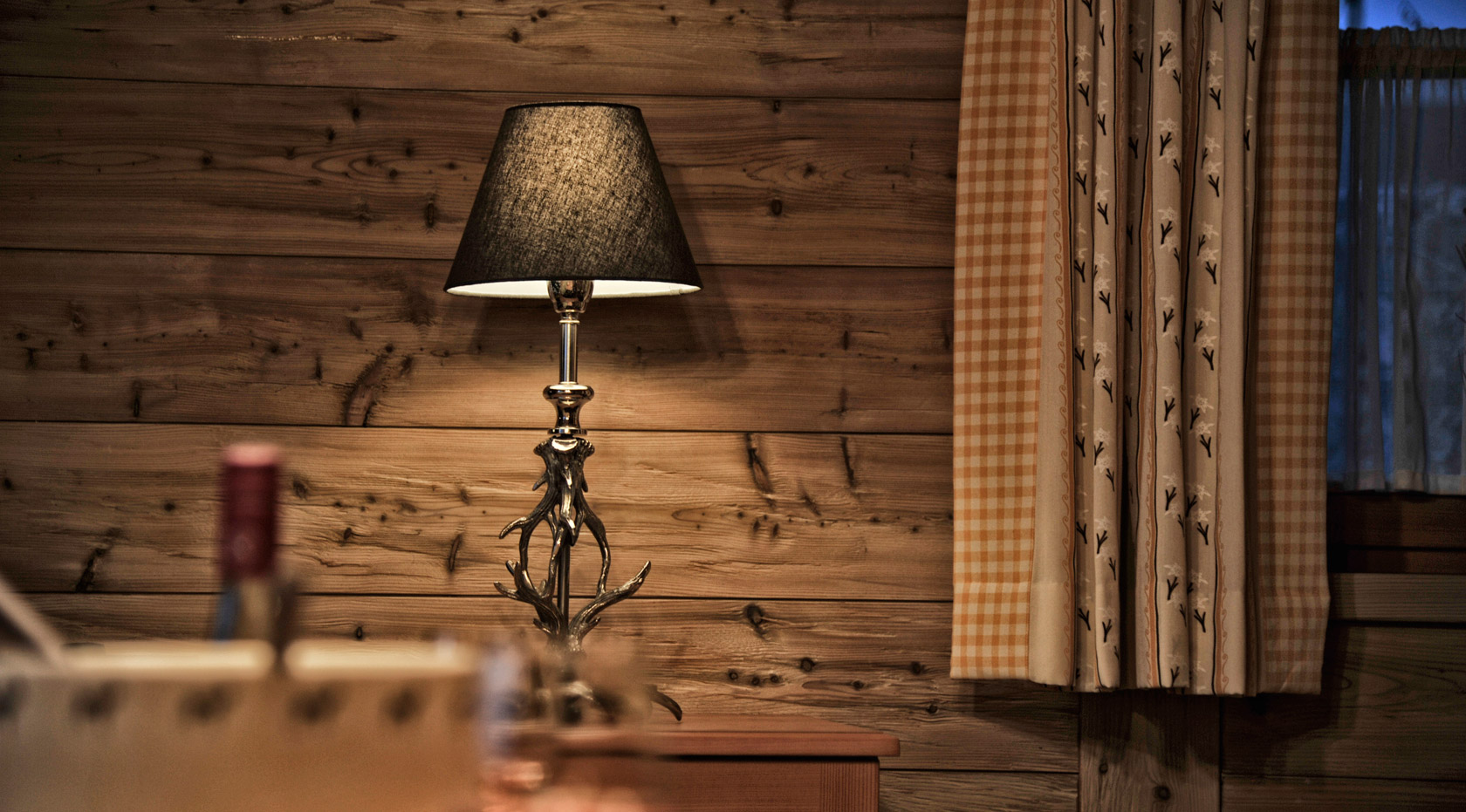 Eine Tischlampe mit Hirschgeweih als Ständer im Chalet Romantika Wiesenruh.